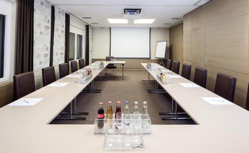 a row of tables in a room with bottles of wine at Posthotel Walhalla Regensburg Ost in Donaustauf