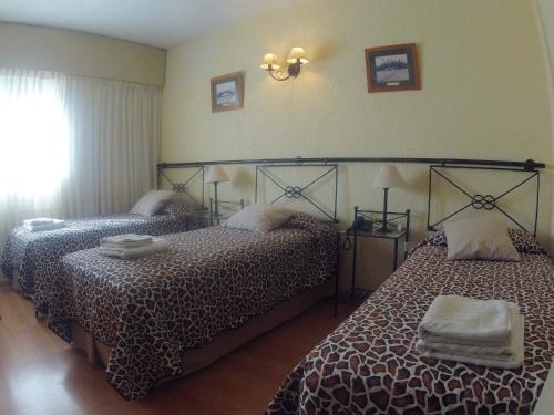 a bedroom with two beds and a window at Hotel Marbella in Punta del Este