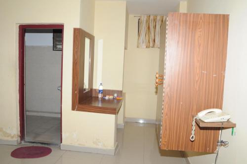 a room with a mirror and a phone on a desk at Hotel Chanma International in Coimbatore