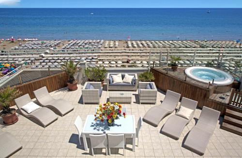 a patio with chairs and a table and a swimming pool at Hotel Ca' Bianca in Riccione