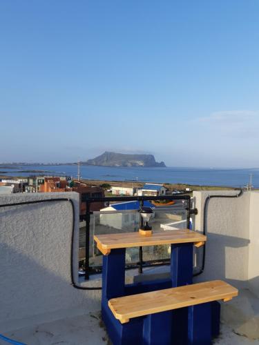 einen Picknicktisch auf einem Gebäude mit Meerblick in der Unterkunft La Masion Benie in Seogwipo