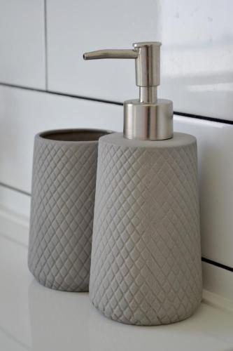 a bathroom sink with a soap dispenser on a counter at Ithaca 1896 Manor in Busselton