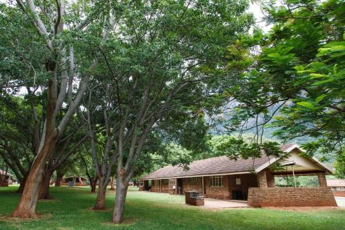 a building in the middle of a park with trees at Swadini, A Forever Resort in Hoedspruit