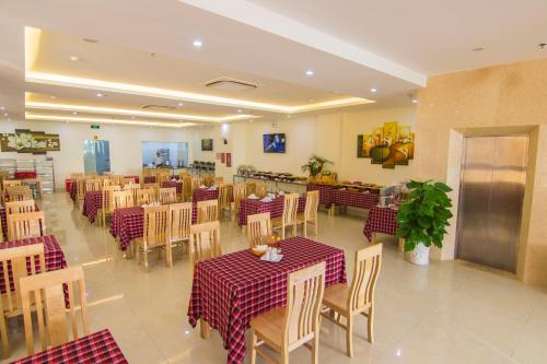 un ristorante con tavoli e sedie con controlli rossi e bianchi di Ngoc Hanh Beach Hotel a Vung Tau