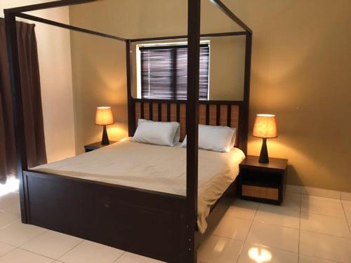 - une chambre avec un lit à baldaquin et deux lampes dans l'établissement Studio Apartment @ Gold Coast Morib Banting Malaysia, à Morib
