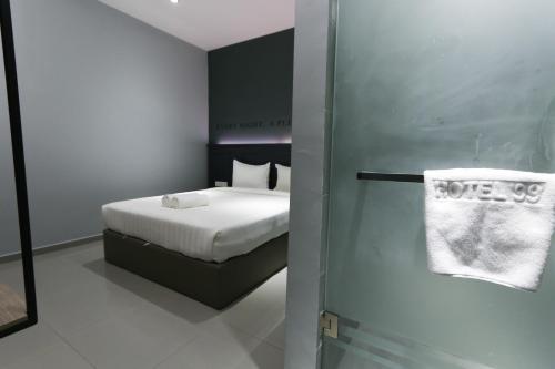 a bedroom with a bed and a towel on a door at Hotel 99 Sri Petaling (Bukit Jalil) in Kuala Lumpur