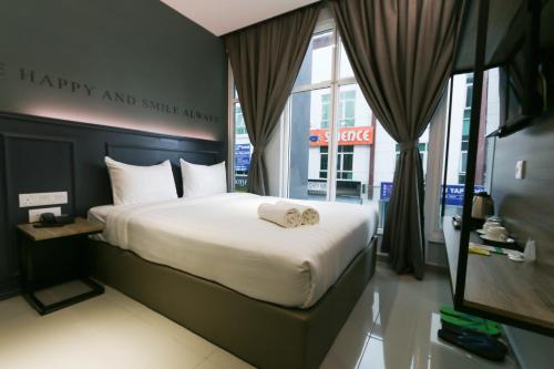 吉隆坡的住宿－Hotel 99 Sri Petaling (Bukit Jalil)，卧室配有一张带幸福和微笑的动画标志的床