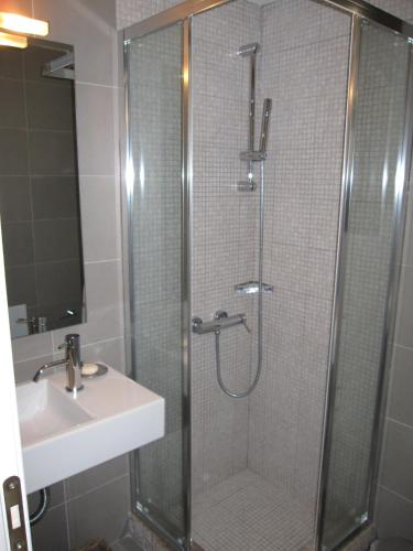 a shower with a glass door next to a sink at Vergopoulos Oliveyard in Mouresi