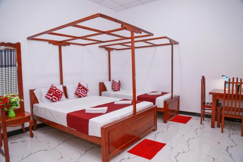 a bedroom with a canopy bed with red and white pillows at Nehansa Resort and safari in Tissamaharama