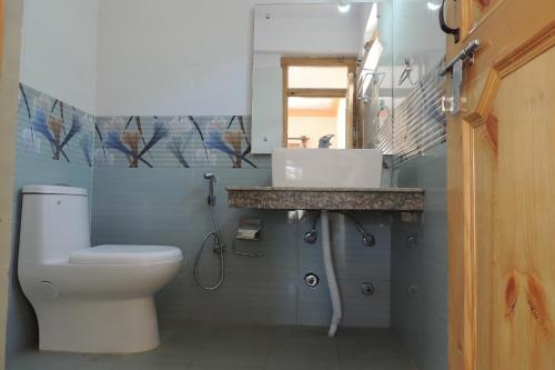 a bathroom with a toilet and a sink at Babu Guest House in Leh