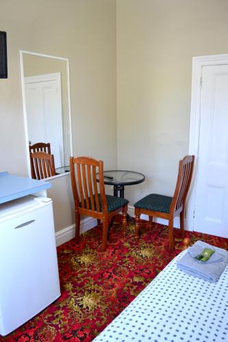 a room with two chairs and a table and a bed at Ithaca 1896 Manor in Busselton