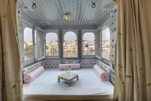 a room with a table in a room with windows at Lake Pichola Hotel in Udaipur