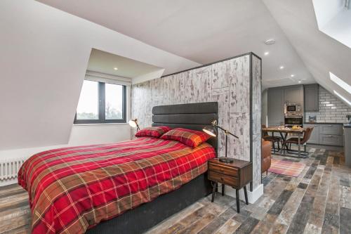 a bedroom with a large bed with a red blanket at Paddock View in Winchester