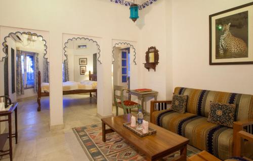 a living room with a couch and a table at Lake Pichola Hotel in Udaipur