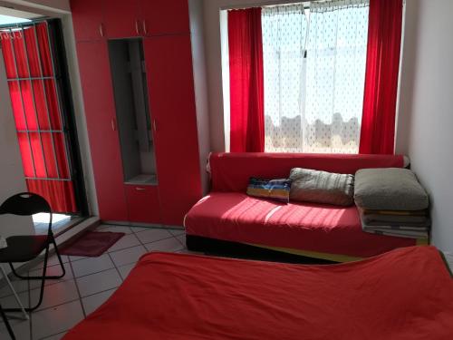 sala de estar con paredes rojas y sofá rojo en Apartmani Filipovic, en Kladovo