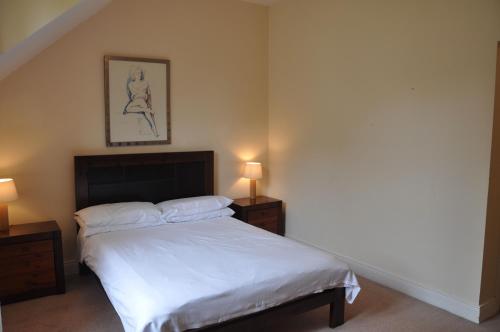 a bedroom with a bed with two night stands and two lamps at Heyward Mews Holiday Homes by Trident Holiday Homes in Swords
