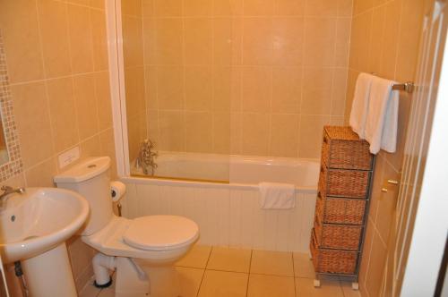 La salle de bains est pourvue de toilettes, d'une baignoire et d'un lavabo. dans l'établissement Heyward Mews Holiday Homes, à Swords