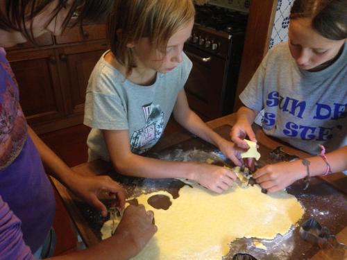 a group of girls making a cake in a kitchen at Agriturismo La Casa sul Poggio in Santo Stefano dʼAveto
