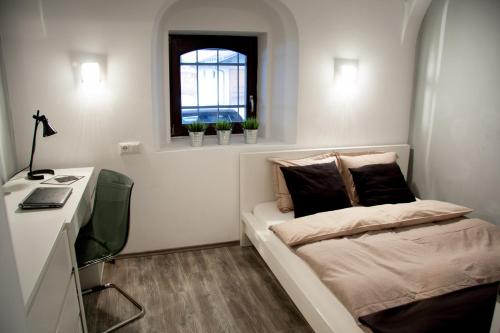 um pequeno quarto com uma cama e uma janela em 4Rooms em Maribor