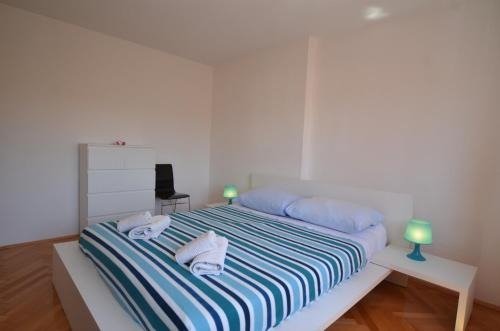 a white bedroom with a bed with towels on it at Apartman Terzić in Rovinj