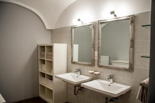 a bathroom with two sinks and a mirror at 4Rooms in Maribor