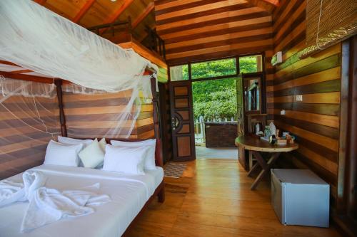 a bedroom with a bed and a table in a room at Tina Nature villa in Ella