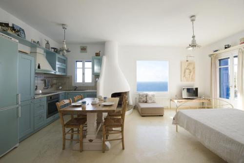 eine Küche und ein Esszimmer mit einem Tisch und einem Bett in der Unterkunft Aigeis-milos in Agia Kiriaki Beach