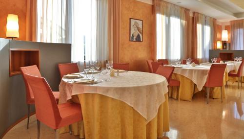 a dining room with tables and chairs with wine glasses at Best Western Cavalieri Della Corona in Cardano al Campo