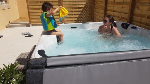 a young boy and a woman in a hot tub at Mas Saint Julien in Cavaillon
