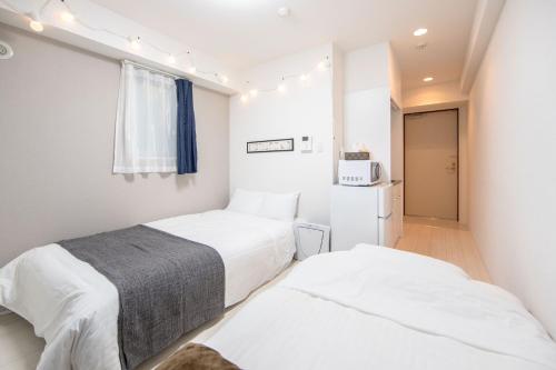 a bedroom with two beds and a refrigerator at NTH Namba - Whole floor 3 flats - Self Check-In Only in Osaka