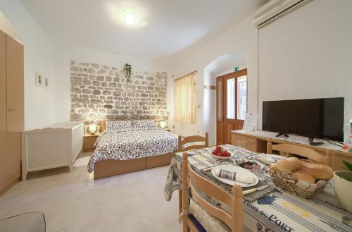 a bedroom with a bed and a table with a television at Hrast in Krk
