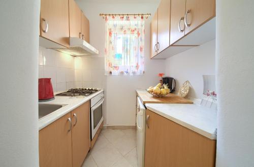 a kitchen with a sink and a stove top oven at Hrast in Krk