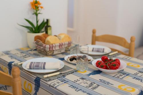 a table with plates of food and a bowl of strawberries at Hrast in Krk