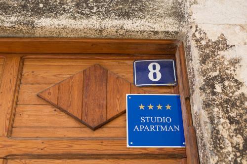 a wooden door with a sign that reads studio apartment at Hrast in Krk