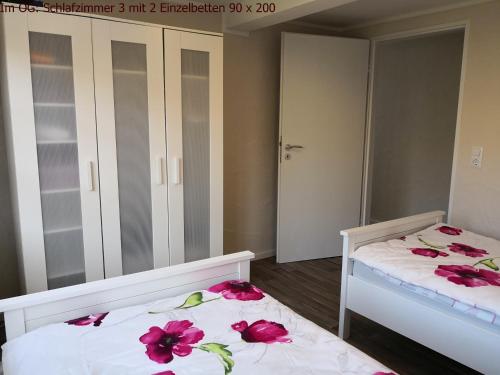 two beds in a bedroom with pink flowers on them at Maifeld-Fewo Sonnenschein in Kerben