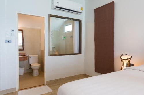 1 dormitorio con 1 cama y baño con aseo en Phi Phi Bayview Resort, en Islas Phi Phi