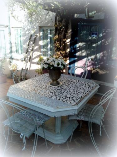 a table with a vase of flowers on a patio at La Maison d'Hocquincourt in Bléneau