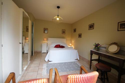 1 dormitorio con 1 cama, mesa y sillas en Chambre d'hôte Courtoux en Saint-Denis-sur-Sarthon