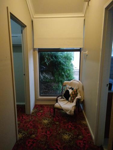 a room with a chair and a large window at Ithaca 1896 Manor in Busselton
