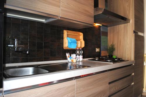 cocina con fregadero y fogones en Bnbook - Ferrarin Apartment en Sesto Calende