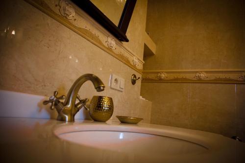 a bathroom sink with a faucet and a bowl on it at Zamek Pod Brzozami, Wynajem Pokoi in Krynica Zdrój