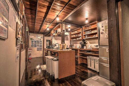 a kitchen with stainless steel appliances and wooden ceilings at K's House Ito Onsen - Historical Ryokan Hostel in Ito