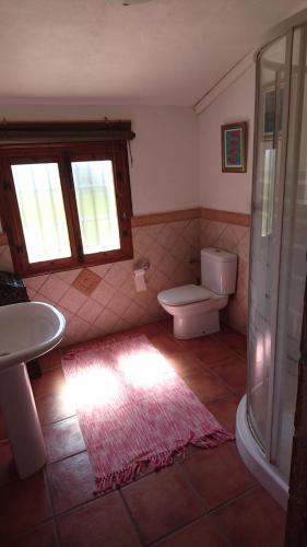 アロラにあるCasita Azaharのバスルーム(トイレ、洗面台付)、窓が備わります。