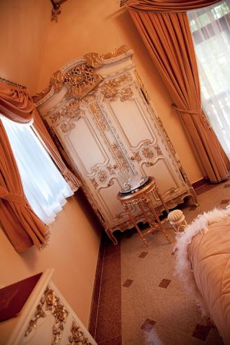 a bedroom with a bed and a table and a window at Zamek Pod Brzozami, Wynajem Pokoi in Krynica Zdrój