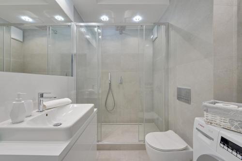 ein Bad mit einer Dusche, einem WC und einem Waschbecken in der Unterkunft Apartament Mistral Gdynia in Gdynia