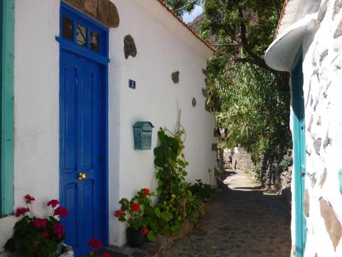 a blue door on a white building with flowers at casarno grande el guro in Calera