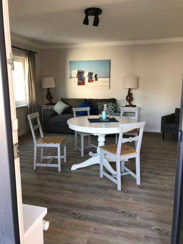 a living room with a white table and chairs at Hotel & Ferienunterkünfte Hus Seeblick in Fehmarn