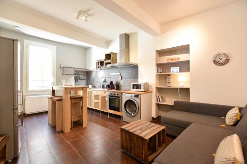 un salon avec un canapé et une cuisine dans l'établissement Succès - Très beau Duplex- Coeur d'Arles- Climatisation, à Arles
