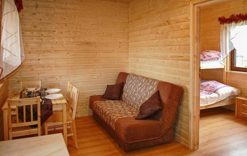 a room with a couch and a table in a cabin at AMANDA Domki letniskowe in Darłowo