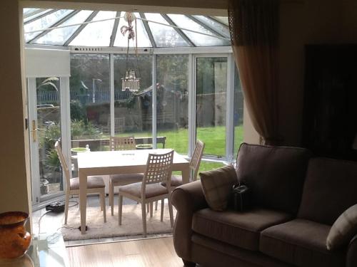 a living room with a couch and a table and chairs at Arron House in Hamilton